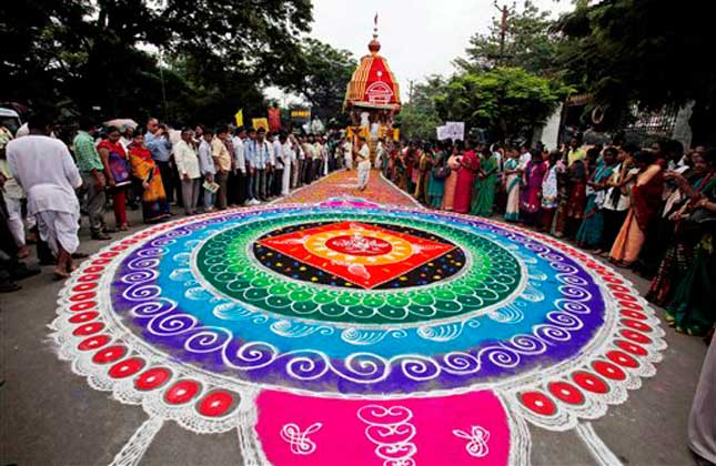 Hindu devotees stand around a traditional artwork made of colored powder during the annual Rath Yatra festival or chariot procession in Hyderabad, India, Wednesday, July 10, 2013. The annual procession of the three idols of lord Jagannath, Balabhadra and Subhadra is taken out in a grand procession in specially made chariots called raths, which are pulled by thousands of devotees. AP Photo