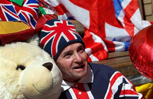 Royal supporter John Loughrey poses with royal baby memorabilia as he waits across the street from St. Mary's Hospital exclusive Lindo Wing in London, Thursday, July 18, 2013. Media are preparing for royal mania as Britain's Duchess of Cambridge plans to give birth to the new third in line to the throne in mid July, at the Lindo Wing. Cameras from all over the world are set to be jostling outside for an exclusive first glimpse of Britain's Prince William and the Duchess of Cambridge's first child. AP Photo