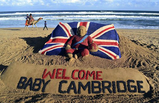 Tourists ride a camel past a sand sculpture created by sand artist Sudarshan Pattnaik to celebrate the birth of the Prince of Cambridge, the son of Britain's Prince William and Kate, Duchess of Cambridge, at a beach in Puri, India, Tuesday, July 23, 2013. AP Photo