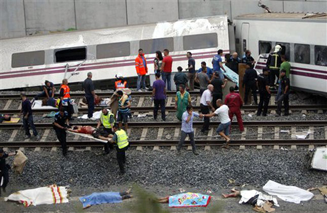 Emergency personnel respond to the scene of a train derailment in Santiago de Compostela, Spain, Wednesday, July 24, 2013. A train derailed in northwestern Spain on Wednesday night, toppling passenger cars on their sides and leaving at least one torn open as smoke rose into the air. Dozens were feared dead, with possibly even more injured. AP Photo