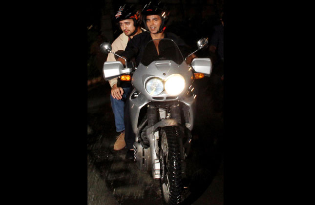 Bollywood actors Akshay Kumar and Imran Khan on a motorbike on their way back from Mumbai airport last night 12 August 2013. (Photo IANS)