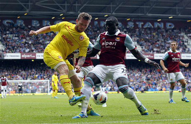 West Ham United's Mohamed Diame, right, competes with Cardiff City's Aron Gunnarsson during their English Premier League soccer match at Upton Park, London, Saturday, Aug. 17, 2013. (AP Photo)