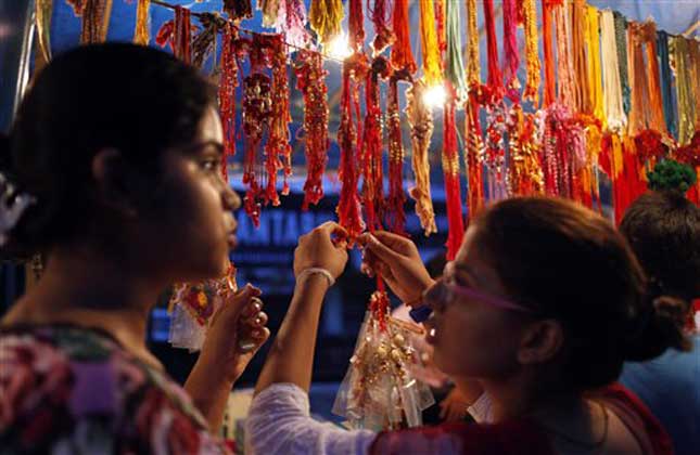 Girls look at rakhis, a sacred thread tied by a sister on the wrist of a brother, ahead of the festival of Raksha Bandhan in Allahabad, India, Saturday, Aug. 10, 2013. The festival of Raksha Bandhan that celebrates the bond between brothers and sisters falls on Aug. 20. (AP Photo)