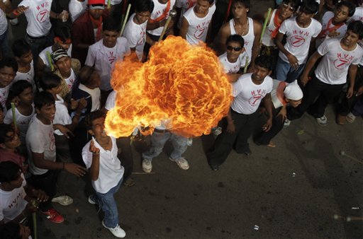 A man displays his skills as others look on during the annual Rath Yatra, or chariot procession of Lord Jagannath, in Ahmadabad, India, Tuesday, July 13, 2010. (AP Photo/Ajit Solanki)