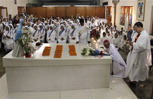 Thomas D'Souza, archbishop of Kolkata, and nuns of the Missionaries of Charity, pray beside the tomb of Mother Teresa as they celebrate her birth anniversary in Kolkata, India, Monday, Aug. 26, 2013. (AP Photo)