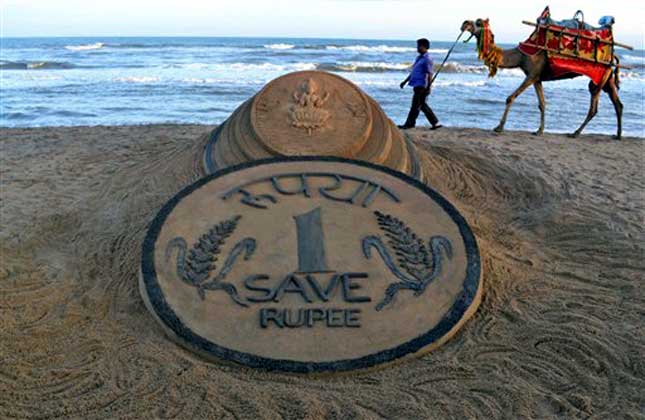 This sand sculpture righlt explains the plight of the Indian Rupee.(AP Photo)