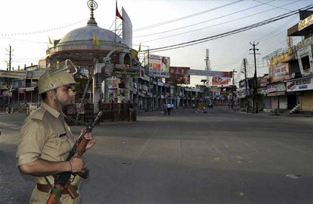 Policeman stands guard during a curfew hours following riots and clashes between two communities in Muzaffarnagar, in the Indian state of Uttar Pradesh. (AP Photo)