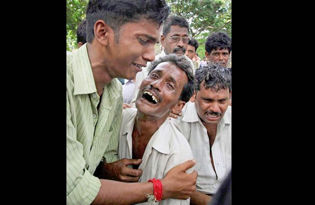 Relatives of victims break down outside a hospital in Birbhum district of West Bengal state, about 250 kilometers (155 miles) north of Calcutta, India, Monday, July 19, 2010. A speeding express train plowed into a stationary passenger train in eastern India on Monday, killing scores of people in a crash so powerful it sent the roof of one car flying onto an overpass. Officials said they could not rule out sabotage. (AP Photo) INDIA OUT