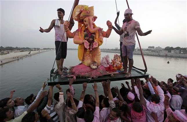 Devotees gather to watch the immersion of idols of elephant headed Hindu God Ganesha, on the banks of the Arabian Sea. (AP Photo)