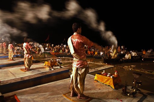 Hindu priests perform evening rituals on the banks of the River Ganges, as tourists watch from boats in Varanasi, India, Sunday, Aug.1, 2010. Varanasi, known as the city of temples and learning, is one of the most sacred places of pilgrimage for Hindus.(AP Photo/Rajesh Kumar Singh)