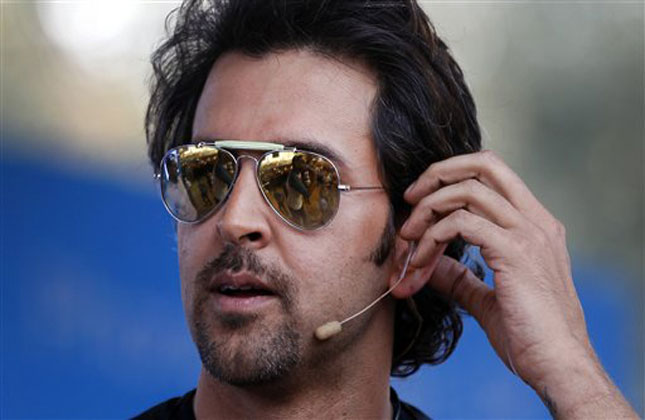 Bollywood actor Hrithik Roshan adjusts his microphone as he interacts with his fans during an event to promote his forthcoming science fiction movie Krrish 3' at a college campus in Bangalore.(AP Photo)