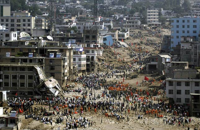 Chinese engineers feared an unstable lake created by the country's deadliest landslide in decades could burst and swamp devastated areas where people are still searching for survivors.At least 702 people have died in northwestern Gansu province after a wave of mud and rocks engulfed swathes of the town Zhouqu at the weekend. Grief stricken people have remained beside buried and destroyed homes where relatives and friends were entombed during the landslide.Rescue workers and residents search for bodies after a powerful landslide gauged a trail through Zhouqu on Sunday.