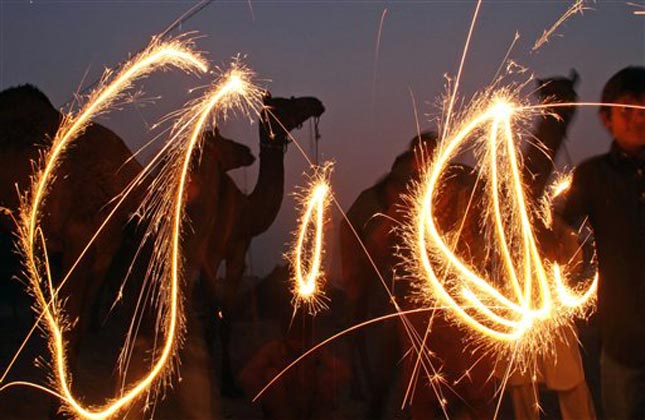 Indian camel herders, gathered for the annual cattle fair, play with fireworks on the eve of Diwali, the Hindu festival of lights, in Pushkar, in the western Indian state of Rajasthan. (AP Photo)