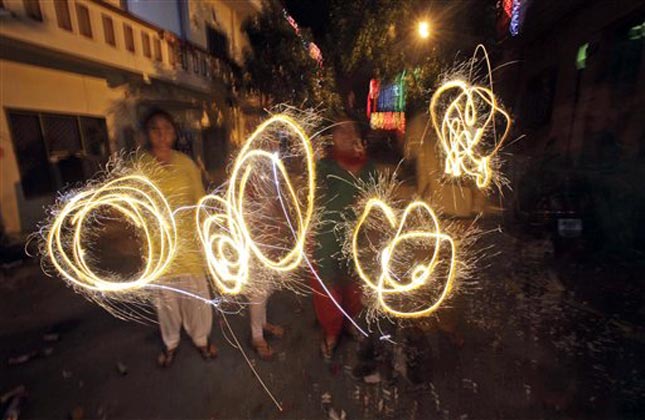 People handle fireworks to celebrate Diwali, the Hindu festival of lights, in Jammu India. (AP Photo)