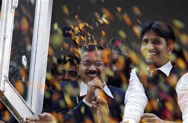 Supporters shower flower petals as Arvind Kejriwal shares the news of success with supporters in Delhi state Assembly elections. (AP Photo)