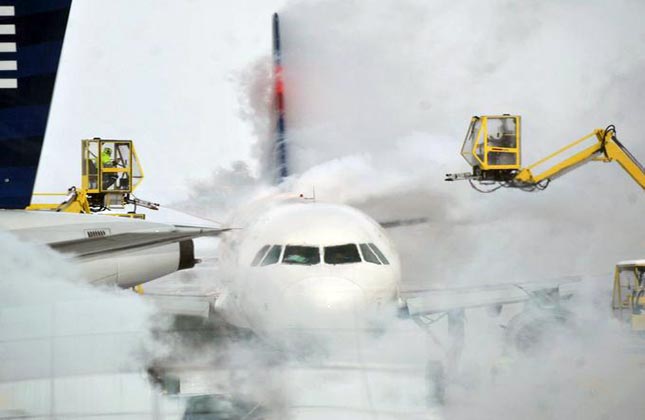 A passenger jet gets de iced outside the terminal at Indianapolis International Airport. (AP Photo)