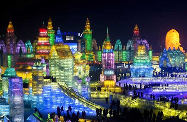 Visitors tour colorful ice structures during the opening ceremony of the Harbin International Ice and Snow festival in Harbin, in northeast China's Heilongjiang province on January 5, 2014. (AP Photo)