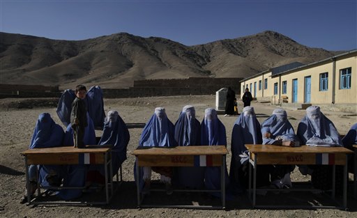 Women polling agents wait for voters at a polling station during the parliamentary elections in Kabul, Afghanistan, Saturday, Sept. 18, 2010. (AP Photo/Saurabh Das)