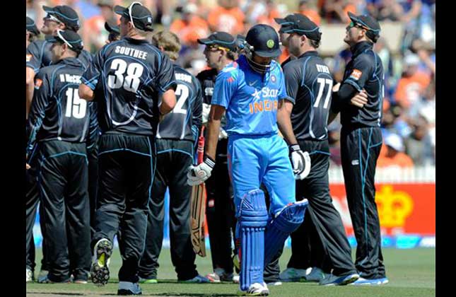 Rohit Sharma walks out for 79 as the New Zealand team watch the replay of the dismissal on the big screen in the fourth one day international cricket match at Seddon Park in Hamilton, New Zealand. (AP Photo)