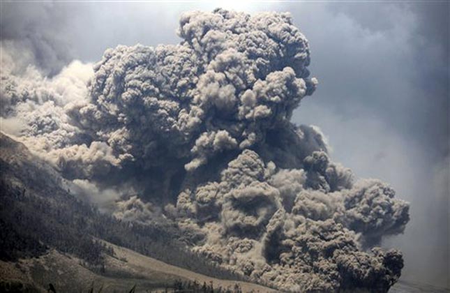 Mount Sinabung releases pyroclastic flows during an eruption as seen from Payung village, North Sumatra, Indonesia. (AP Photo)