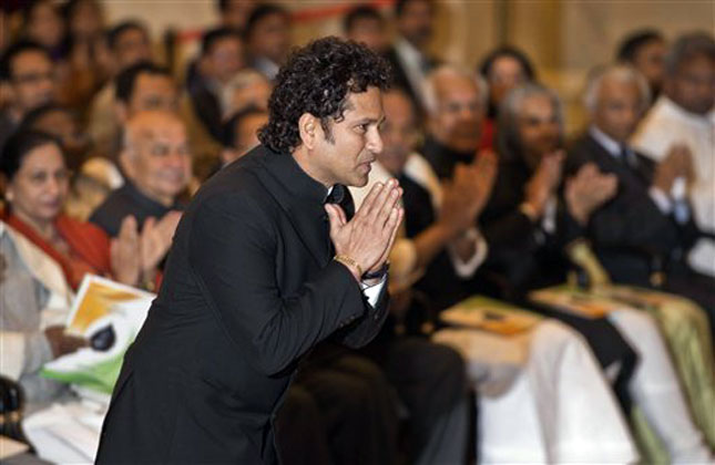India's cricket icon Sachin Tendulkar greets President Pranab Mukherjee as he walks to receive the Bharat Ratna award during an awards ceremony at the Presidential Palace in New Delhi. (AP Photo)