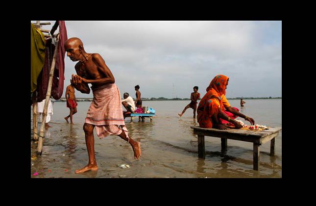 In this photo taken on Sept. 21, 2010, a flower vendor waits for customers by the river side in Ayodhya, India. On Friday, Sept. 24, 2010, an Indian court will finally issue its ruling in a 60 year old case and decide whether a disputed site in Ayodhya should be given to the Hindu community to build a gigantic Rama temple or should be returned to the Muslim community to rebuild a 16th century Mosque. (AP Photo/Rajesh Kumar Singh)