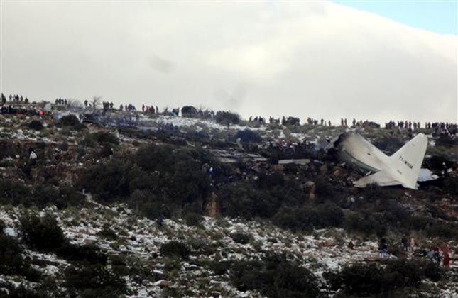 People look at the wreckage of Algerian military transport plane after it slammed into a mountain in the country's rugged eastern region. ( AP Photo)