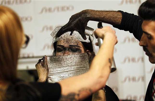 A model gets her make up backstage before a show during the ModaLisboa fashion week, in Lisbon, Portugal