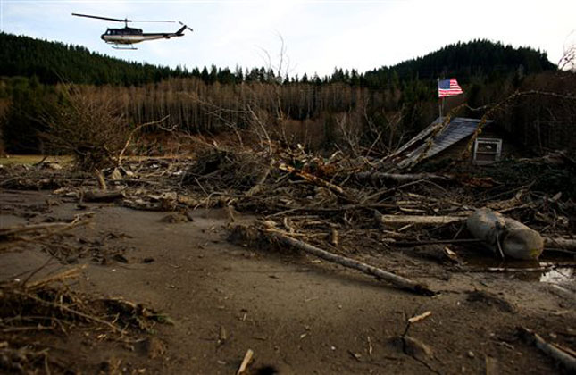 From a helicopter, Snohomish County Sheriff Ty Trenary surveys the wreckage of homes destroyed in Saturday's mudslide. (AP Photo)