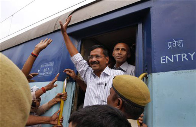 Aam Aadmi Party chief Arvind Kejriwal waves to supporters as he arrives in a train for election campaign in Varanasi. (AP Photo)