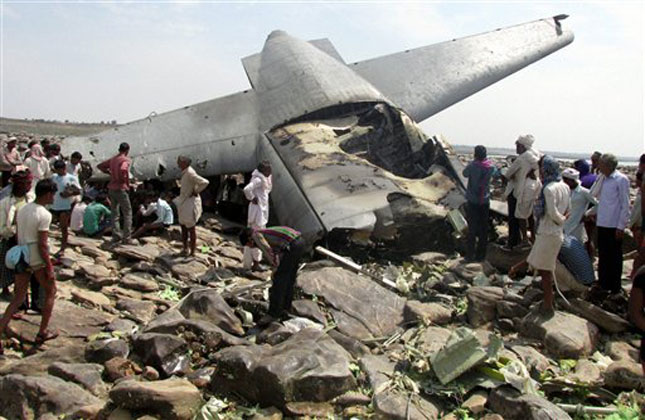 Indian villagers crowd around the debris of an Indian air force cargo plane that crashed near Karauli village in the central Indian state of Madhya Pradesh. (AP Photo)
