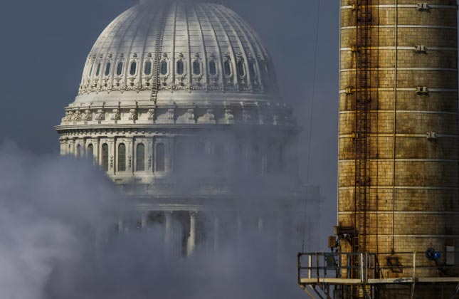 The dome of the US Capitol is seen behind a smokestack from the Capitol Power Plant, the only coal burning power plant in the nation's capitol, in Washington, DC.