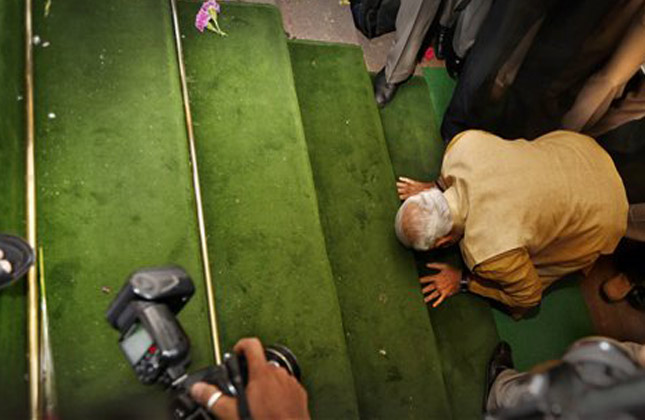 India's next prime minister and Hindu nationalist Bharatiya Janata Party (BJP) leader Narendra Modi, bends down on his knees on the steps of the Indian parliament building as a sign of respect as he arrives for the BJP parliamentary party meeting in New Delhi, India, Tuesday, May 20, 2014. The BJP on Tuesday started putting together a new government by formally choosing Modi to be the country's next prime minister following a resounding victory in national elections. (AP Photo)