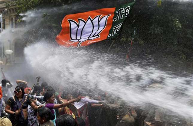 Women activists of Bharatiya Janata Party, flag seen top, face police water cannons as they demonstrate outside the office of Uttar Pradesh state chief minister Akhilesh Yadav, demanding that he crack down on an increasing number of rape and other attacks on women and girls, in Lucknow, India, Monday, June 2, 2014. Police used water cannons to disperse hundreds of women who were protesting Monday against a rise in violence against women in the northern Indian state where two teenagers were gang raped last week and later found hanging from a tree.