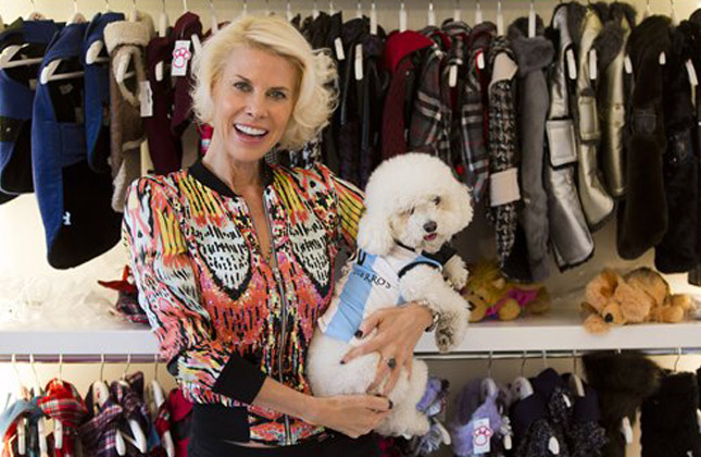 Karen Reichardt, owner of a pet store, poses with her dog wearing a garment resembling the jersey of the Argentine national soccer squad in Buenos Aires, Argentina, Thursday, June 5, 2014. Reichardt designed a number of garments for pets ahead of the World Cup that starts next week in Brazil. (AP Photo)