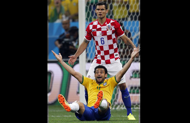 Brazil's Fred, bottom, raises his arms after a penalty was called against Croatia's Dejan Lovren, top, by referee Yuichi Nishimura, from Japan, during the group A World Cup soccer match between Brazil and Croatia in the opening game of the tournament at the Itaquerao Stadium in Sao Paulo, Brazil, Thursday, June 12, 2014. Brazil was issued a penalty kick following the play leading to a goal by Neymar helping Brazil to a 3 1 victory. (AP Photo)