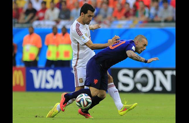 Netherlands' Wesley Sneijder, right, is challenged by Spain's Sergio Busquets during the group B World Cup soccer match between Spain and the Netherlands at the Arena Ponte Nova in Salvador, Brazil, Friday, June 13, 2014. (AP Photo)