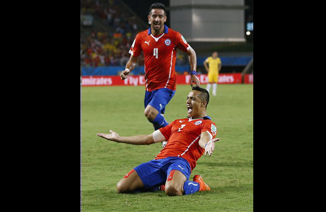 Chile's Mauricio Isla (4) watches as Alexis Sanchez celebrates after scoring his side's first goal during the first half of the group B World Cup soccer match between Chile and Australia in the Arena Pantanal in Cuiaba, Brazil, Friday, June 13, 2014. Sanchez produced a dynamic performance to lead Chile to a 3 1 win over Australia. (AP Photo)