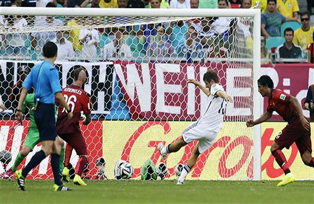 Germany's Thomas Mueller (13) kicks at the Portugal net to score his side's third goal during the group G World Cup soccer match between Germany and Portugal at the Arena Fonte Nova in Salvador, Brazil, Monday, June 16