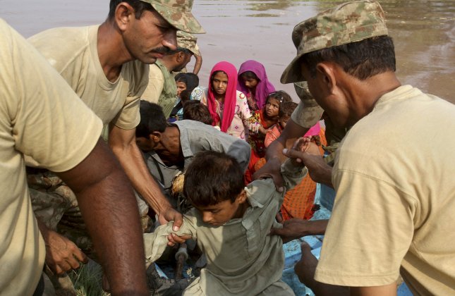 Thousands of people fled their homes in Pakistan on Wednesday as monsoon flooding that has already inundated the disputed Himalayan region of Kashmir coursed down onto the plains, causing the Chenab River to breach its banks.