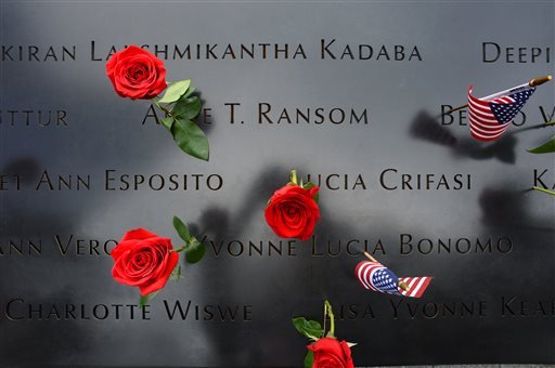 Roses and flags left by loved ones are placed on the names inscribed at the North Pool during memorial observances on the 13th anniversary of the Sept. 11 terror attacks on the World Trade Center in New York, Thursday, Sept. 11, 2014. Family and friends of those who died read the names of the nearly 3,000 people killed in New York, at the Pentagon and near Shanksville, Pennsylvania. (AP Photo)