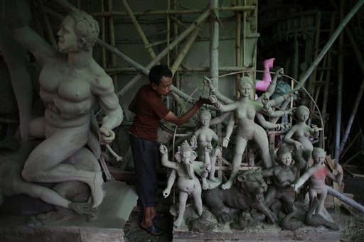 An Indian artist smokes as he takes a break while preparing idols of Hindu goddess Durga ahead of the Durga Puja festival in New Delhi. During this festival, the goddess is worshipped for her mythological victory over the evil forces.