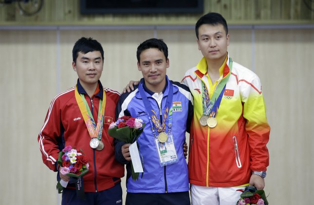 Winner India's Jitu Rai, center, silver medalist Vietnam's Nguyen Hoang Phuong, left, and bronze medalist China's Wang Zhiwei pose for the media during the medal ceremony for the 50m Pistol Men at the Ongnyeon International Shooting Range for the 17th Asian Games in Incheon, South Korea,