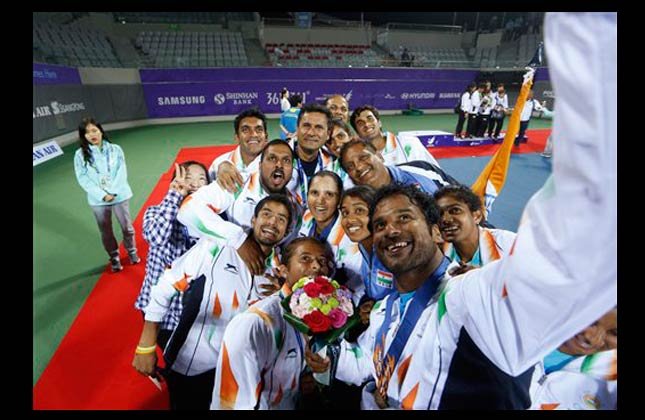 Gold medal winners India's Sania Mirza, center and Saketh Sai Myneni, right take a selfie with their teammates after winning the mixed doubles tennis match at the 17th Asian Games in Incheon, South Korea, Monday, Sept. 29, 2014. (AP Photo)