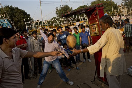 Indians gather around a punching machine at a local fair during Dussehra celebrations, at Ramlila ground in New Delhi