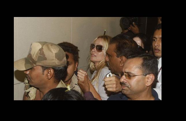 Security guards and Airport officials try to protect U.S. actress Pamela Anderson from media after she arrived at the Chhatrapati Shivaji International Airport in Mumbai, India, Monday, Nov 15, 2010. Anderson is in India to take part in a TV reality show 'Big Boss Season 4' which is hosted by Bollywood actor Salman Khan .(AP Photo/Rafiq Maqbool)
