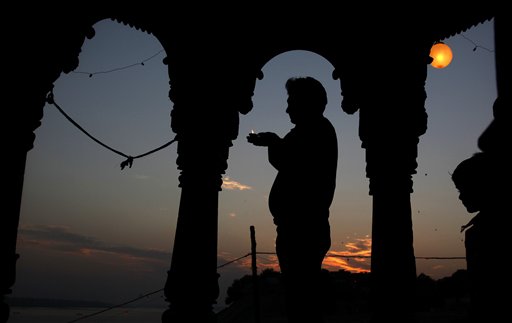 A Hindu devotee is silhouetted as he performs rituals during Karthik Purnima in Allahabad, India, Sunday, Nov. 21, 2010. Karthik Purnima is a Hindu holy day celebrated on the full moon day or the fifteenth lunar day of Karthik (November December) month of the Hindu calendar. (AP Photo/Rajesh Kumar Singh)