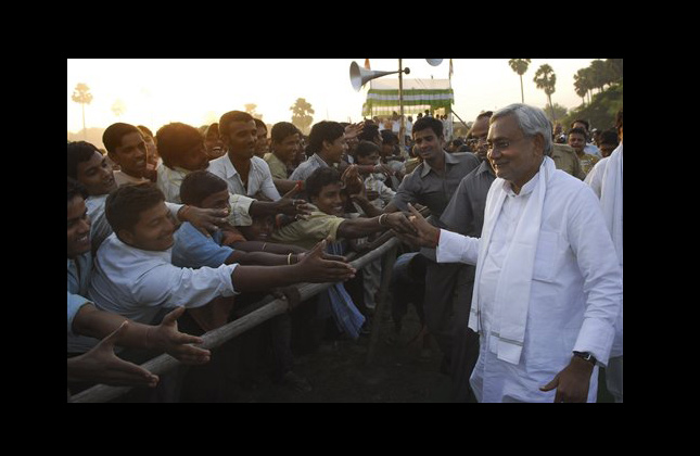 This photo dated Friday, Oct. 29, 2010, shows a Bihar state Chief Minister Nitish Kumar, right, shaking hands with the crowd during an election rally in Maner, India. Over past five years, Kumar built roads, fought crime and helped rescue Bihar state from a near anarchy that had condemned most of its 83 million people to a life of fear and poverty. A six stage vote in the region long dominated by caste based politics ends Saturday. (AP Photo/Prashant Ravi)