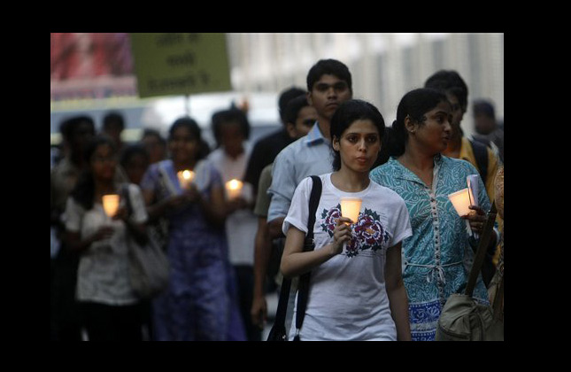 People hold candles and pay tribute to victims of the Mumbai terror attacks, in Mumbai, India, Thursday, Nov. 25, 2010. India rebuked Pakistan again Thursday for not punishing the masterminds of the Nov. 26, 2008 assault on the Indian financial capital that killed 166 people. (AP Photo/Rajanish Kakade)