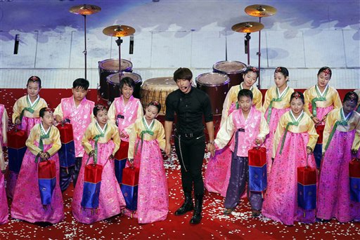 South Korean pop singer Rain performs with children during the closing ceremony of the 16th Asian Games in Guangzhou, China, Saturday, Nov. 27, 2010. (AP Photo/Eugene Hoshiko)